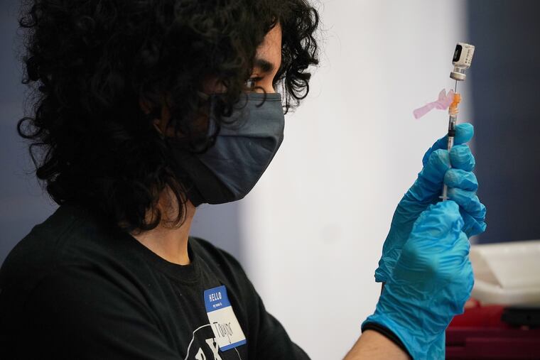 Taylor Pagan prepares doses of the Pfizer COVID-19 vaccine during a vaccination clinic at Cheltenham High School in May.
