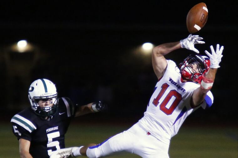 Neshaminy receiver Mike Garlick (right) tries in vain to make an acrobatic catch in a nonleague contest against Pennridge last season.