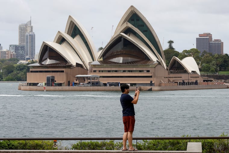 A man films the harbour foreshore on his mobile phone ahead of New Years Eve in Sydney, Australia, on Thursday.