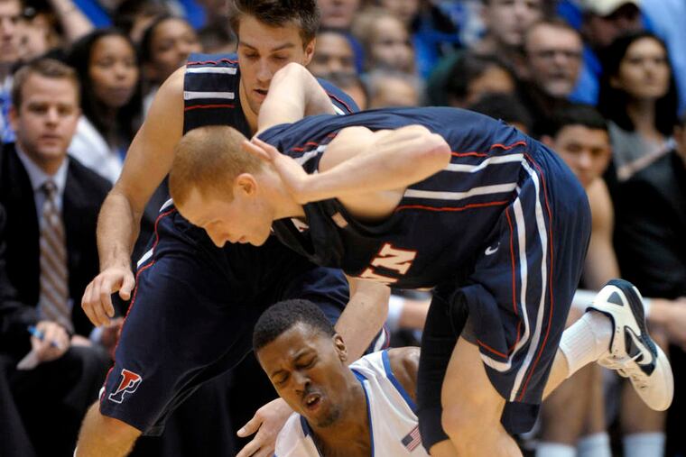 Duke's Tyler Thornton hangs onto the ball as Penn's Tyler Bernardini (rear) and Zack Rosen fall over him in the first half.