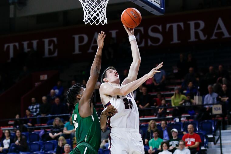 Penn forward AJ Brodeur shoots the basketball over Dartmouth forward Chris Knight during the first half.