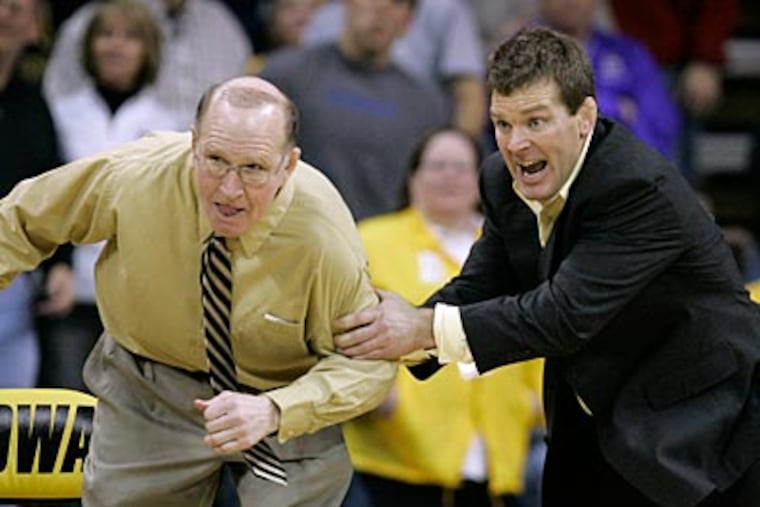 Iowa wrestling coach Tom Brands and assistant coach Dan Gable (left) react during a match. (Charlie Neibergall/AP Photo)