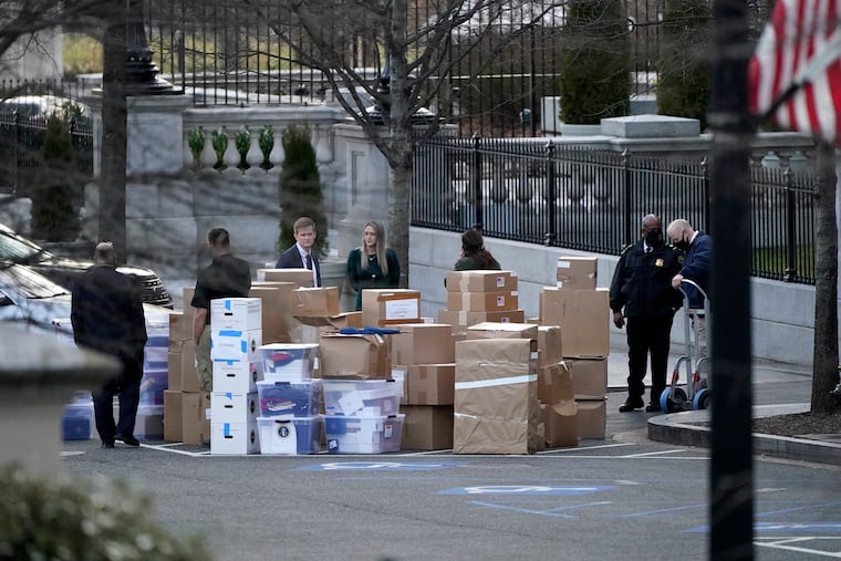 People wait for a moving van after boxes were moved out of the Eisenhower Executive Office building inside the White House complex on Jan. 14, 2021, in Washington.
