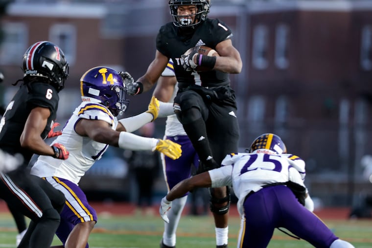 Imhotep Charter # 1 Jabree Wallace-Coleman splits Roman Catholic defenders # 14 Brandon Mack and # 25 Dazhaun Hopkins during the Imhotep Charter vs. Roman Catholic H.S. football PIAA Class 5A playoff game at the Northeast Supersite on Nov. 19. Imhotep Charter fell to Pine-Richland in the PIAA state Championship game on Dec. 9.