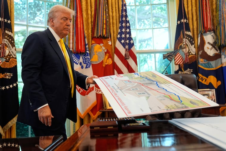 President Donald Trump holds a chart as he discusses the economy in the Oval Office of the White House, Aug. 7, 2025, in Washington.