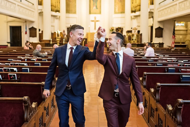 Brad Luna and Adam Ouanes walking up the aisle together as new husbands.