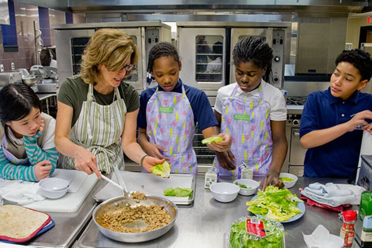 Inquirer food editor Maureen Fitzgerald demonstrates how to assemble a turkey lettuce wrap to Henry Lawton Elementary School fifth grade students Kimberly Luu, Nysirah Hall, Aneza Abalo and Nicholas Rodriguez. ( CLEM MURRAY / Staff Photographer )