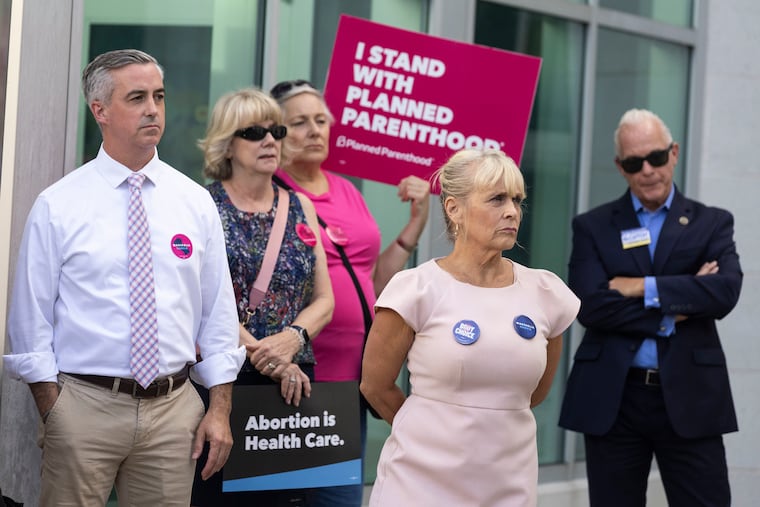Bucks County Democratic Commissioners Bob Harvie and Diane Marseglia listen as Judge Dan McCaffery stands nearby during a rally outside of the Middletown Township Police Department and Administrative Offices in Langhorne on Oct. 5.