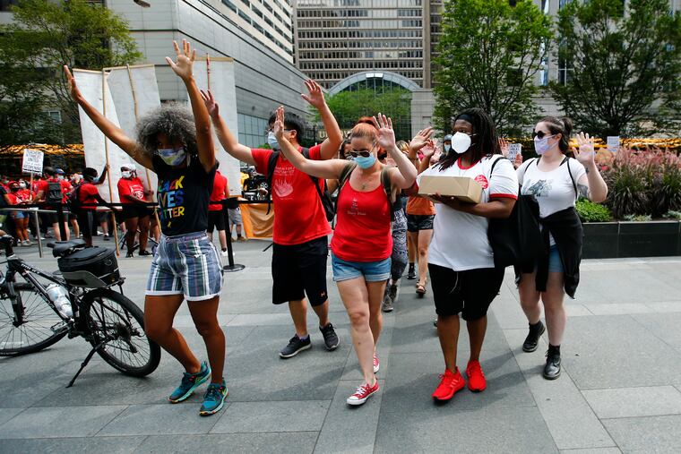 Organizers walk to front entrance of the Comcast Center in Center City with signed petitions for affordable internet on Monday, August 3, 2020. Advocates, parents, teachers, community members and students attempted to deliver over 2500 letters to Comcast CEO Brian Roberts, demanding he open up the residential hotspots students need to get online and improve Internet Essentials beyond the slow speeds and spotty service it currently provides.