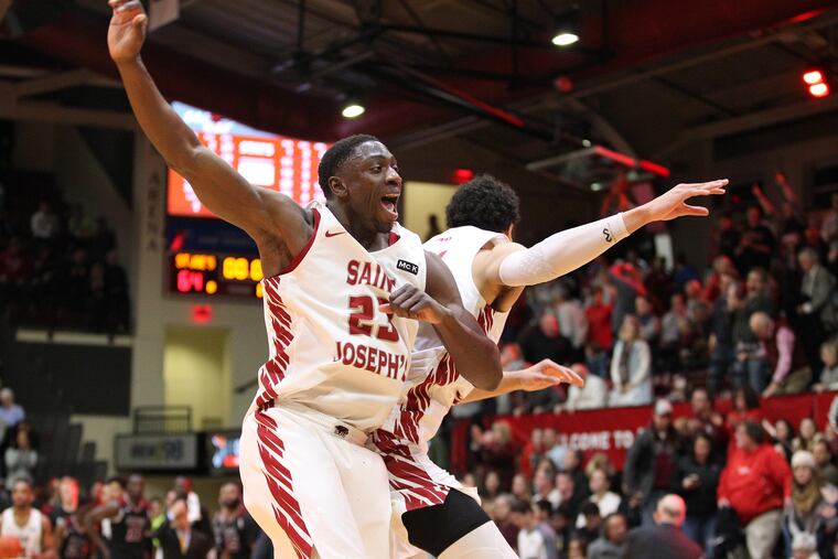 Markell Lodge, left, and Lorenzo Edwards of St. Joseph’s celebrate after their 64-62 victory against UMass on Feb. 2, 2019.