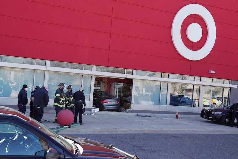 Officials stand at the scene where a driver crashed a Hyundai through a window at the front of the Target store on Route 38 in Cherry Hill, N.J., on Thursday, Feb. 26, 2021.