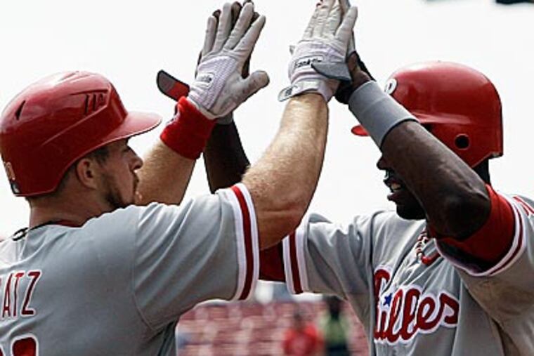 Erik Kratz (left) is congratulated by John Mayberry Jr. after hitting a three-run home run against the Reds. (Al Behrman/AP)