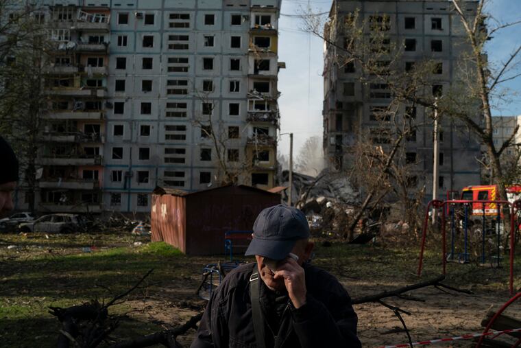 Mucola Markovich, 76, wipes a tear as he stands next to a residential building that was heavily damaged after a Russian attack at a residential area in Zaporizhzhia, Ukraine, Sunday, Oct. 9, 2022.