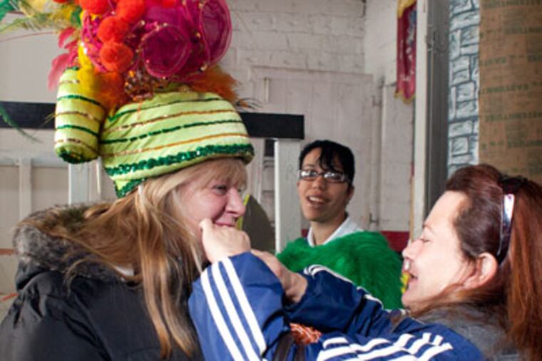 Members of the Murray Comic Club work on their costumes and floats in preparation for Sunday's Mummer's parade. Francesca Costello, right, helps Connie Niglio, left with her costume. Ed Hille / Staff Photographer)