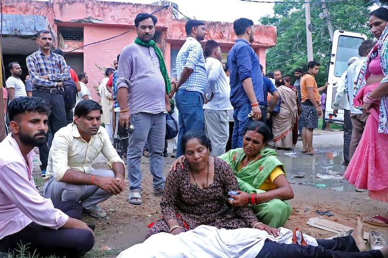 Women mourn next to the body of a relative outside the Sikandrarao hospital in India on Tuesday, July 2, 2024.