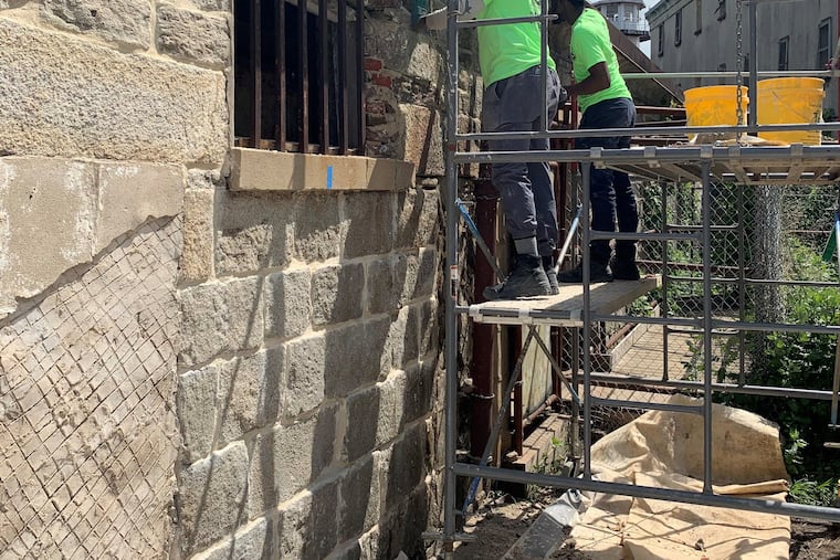 Previous Rebuild academy participants restore the walls of the Eastern State Penitentiary.