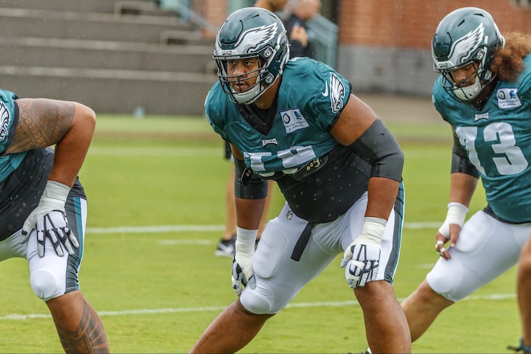 Eagles offensive lineman, #72, Halapoulivaati Vaitai, center, stretches during warm ups, before Sunday's practice, in the rain, at the NovaCare Center. MICHAEL BRYANT / Staff Photographer