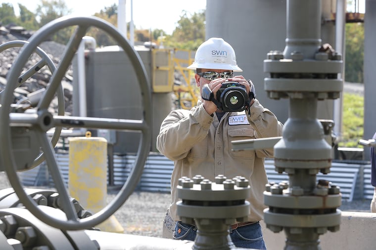 Ryan Klemish scans a well site in New Milford Township, Pa. with an infrared camera for gas leaks.