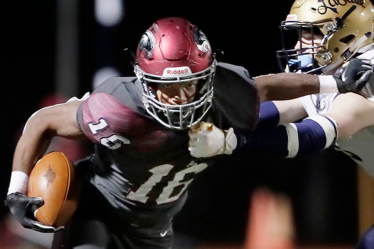 St. Joseph's Prep's Malik Cooper is grabbed by La Salle's Griffin Zobel in the first half. The Prep won, 52-7.