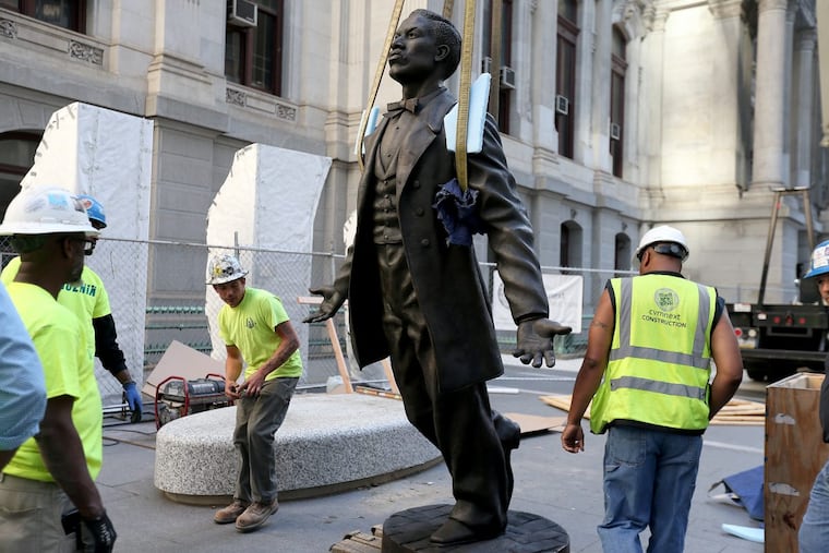 Workers installing a statue of Octavius V. Catto at City Hall on Sunday. The likeness of the 19th-century civil rights advocate is one part of a Catto monument that will be unveiled Tuesday.