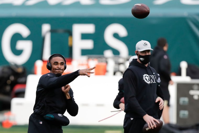 Eagles quarterback Jalen Hurts warms up alongside Carson Wentz before last week's game against the Saints.