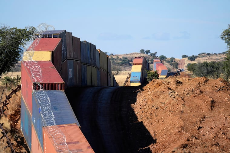A long row of double-stacked shipping containers provide a new wall between the United States and Mexico in the remote section area of San Rafael Valley, Ariz., Thursday, Dec. 8, 2022. Arizona Gov. Doug Ducey will take down a makeshift wall made of shipping containers at the Mexico border, settling a lawsuit and political tussle with the U.S. government over trespassing on federal lands.