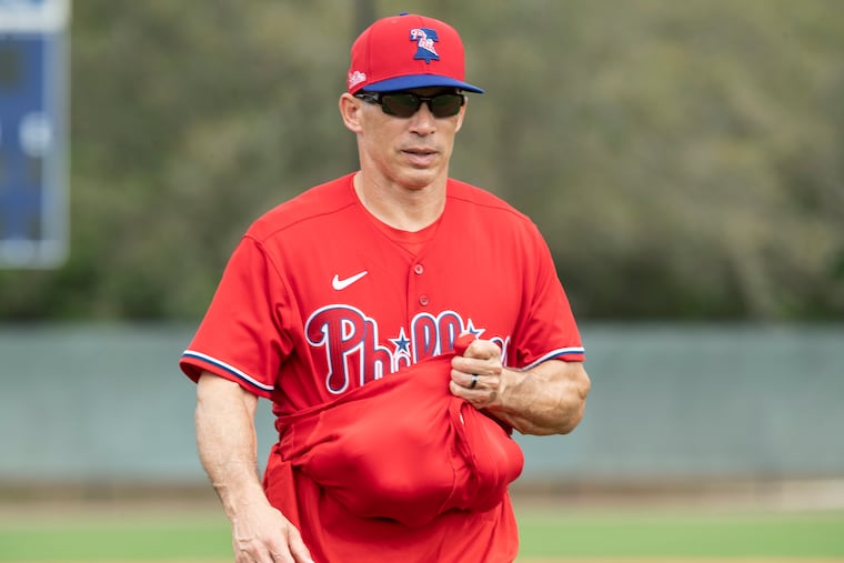 Phillies manager Joe Girardi collects baseballs at spring training.