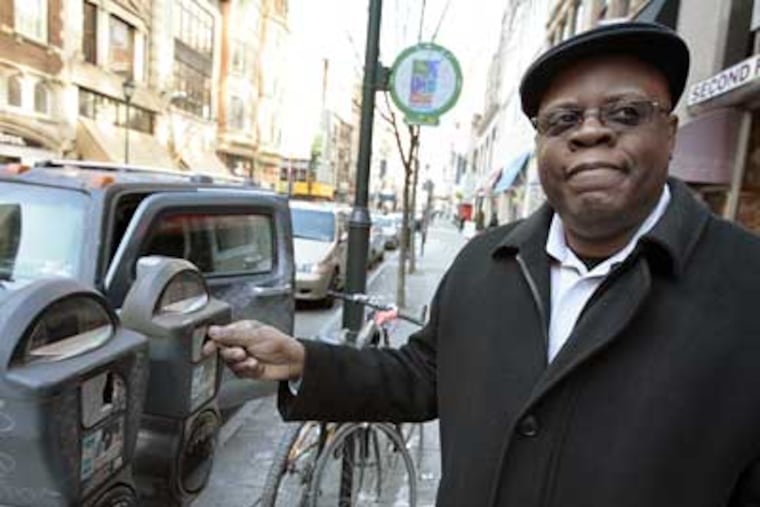 Victor Strong of Roxborough puts quarters in the meter after parking on Chestnut Street on Thursday. (Elizabeth Robertson / Staff Photographer)