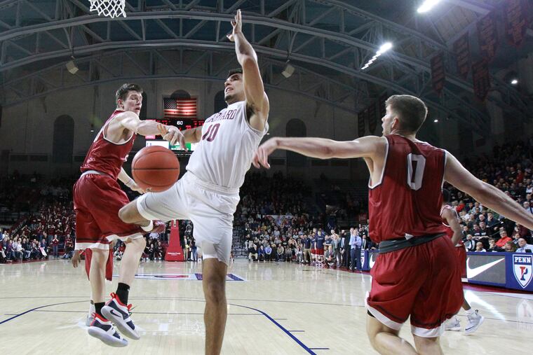 AJ Brodeur, left of Penn strips the ball away from Noah Kirkwood, center of Harvard during the 2nd half on Feb. 16, 2019. Max Rothschild of Penn is right.