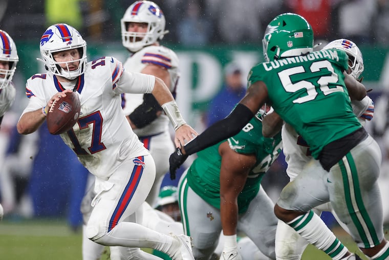 Bills quarterback Josh Allen (left) avoids a tackle attempt by former Eagles linebacker Zach Cunningham during the 2023 matchup between the teams.