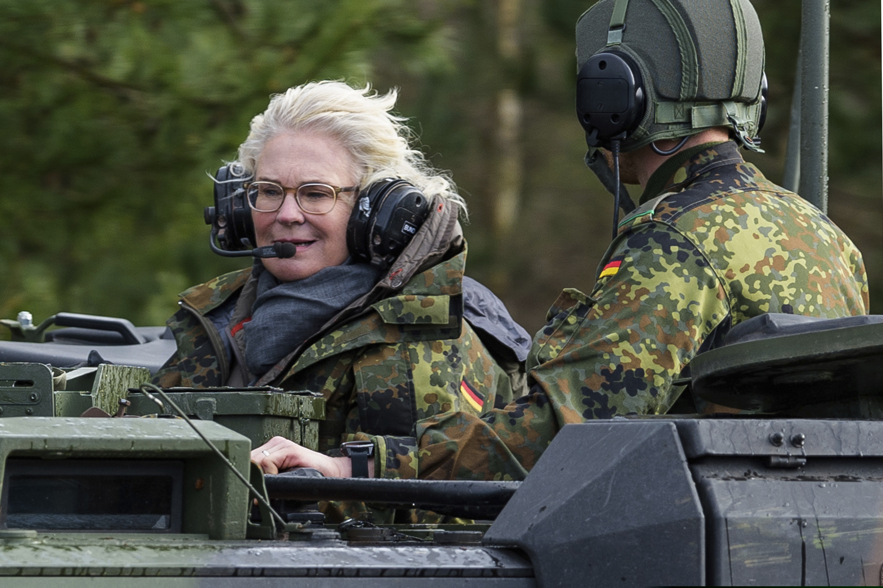 German Defense Minister Christine Lambrecht (left) visits a tank training brigade 9 in Munster, Germany, Monday. Germany says it will add up to 350 troops to a NATO battlegroup it leads in Lithuania, an announcement that comes amid tensions between Russia and Ukraine.