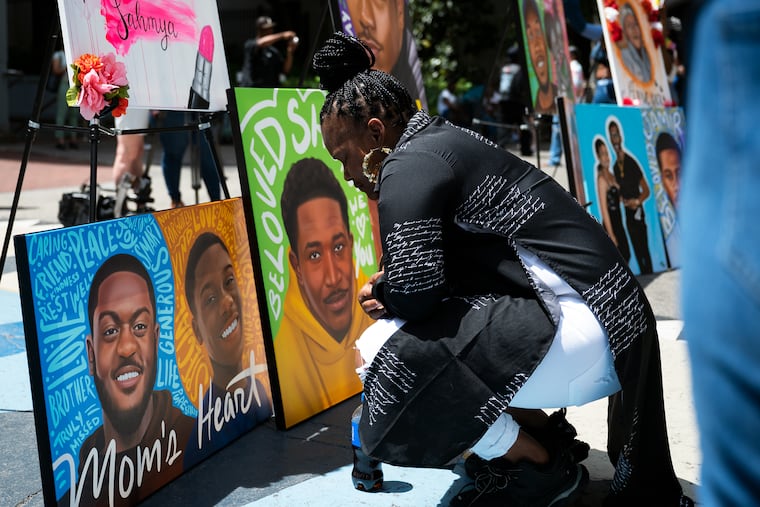 Chimere Quattlebaum views a painting of her two sons Thomas Page, 19, (left) and Thalyl Taylor, 17, both of whom were fatally shot. The paintings are part of “A Mother’s Love" exhibit.