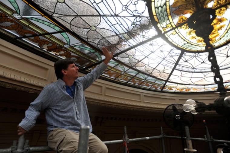 Stained-glass artist Randall Claggett checks the connections of restored stained-glass panel that he installed in the rose ceiling of the old Elkins family mansion in Elkins Park. September. 27, 2013 ( RON TARVER / Staff Photographer )
