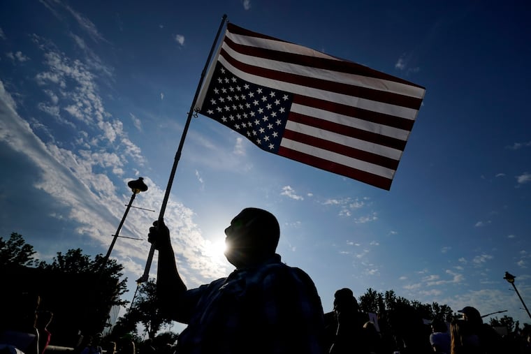 Abortion-rights supporter Ryan Maher, of Des Moines, Iowa, carries a flag during a march to the Iowa governor's mansion after the Supreme Court ended constitutional protections for abortion Friday.