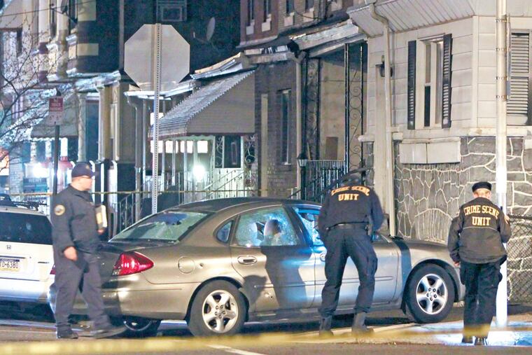 Investigators look over a suspect's car at the intersection of 51st Street and Willows Street in the Kingsessing section of Philadelphia, after police discharged their weapons wounding the driver. For the Inquirer and Daily News/ Joseph Kaczmarek
