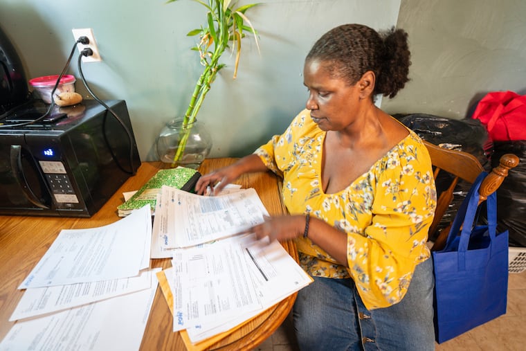Janell Johnson-Washington looks through previous energy bills at her home, in Philadelphia, Thursday, June 29, 2023.