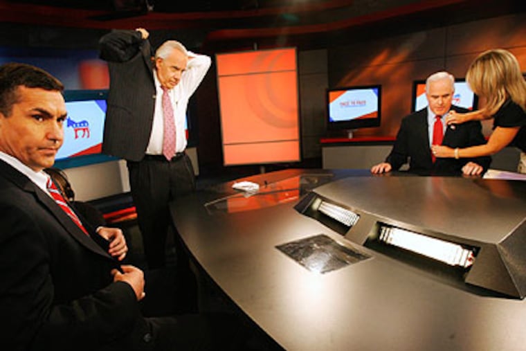 At left is Brian Lentz (D), moderator Larry Kane and candidate Pat Meehan (R) getting his suit microphone adjusted before the start of a televised debate Thursday. (Alejandro A. Alvarez / Staff Photographer)
