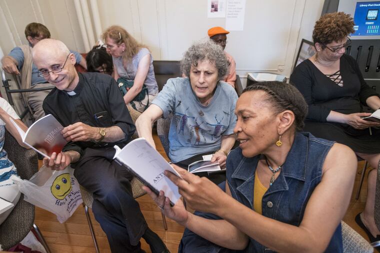 Sylvia Elias, center, and Patricia Burton, 2nd from right, look over "Anthology." They both have works in the book.
