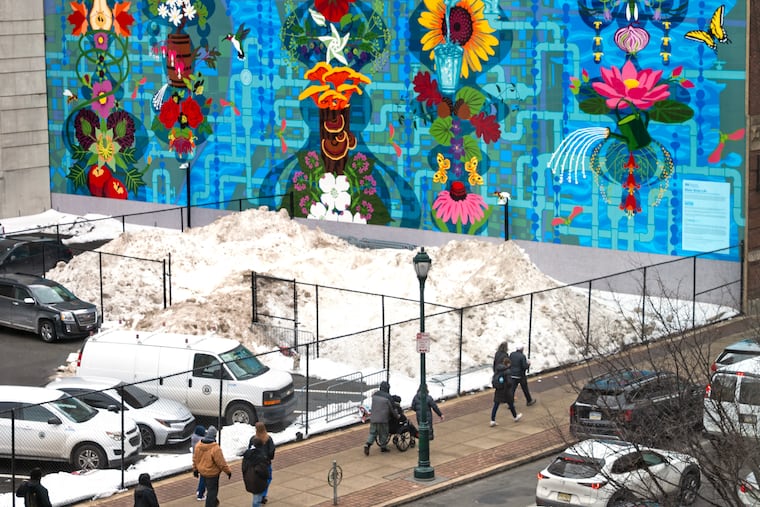 Snow is filed up in front of “Water Gives Life” by Mural Arts Philadelphia artists Eurhi Jones and David McShane in the 1300 block of Arch Street. The snow is showing its age but also its tenacity.