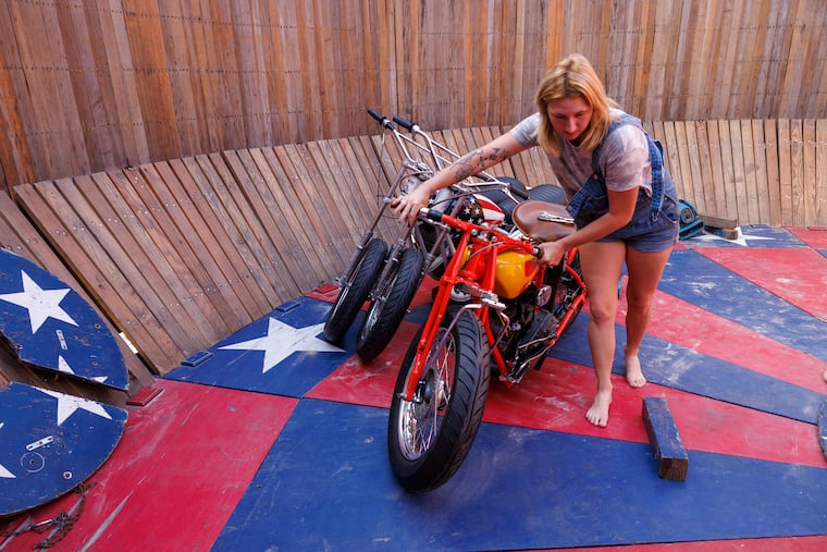 Ariell Flight from West Chester moves a classic Indian motorcycle during setup. Wall of Death acrobatic riders performed at the Race of Gentlemen in Wildwood, N.J., this past weekend.