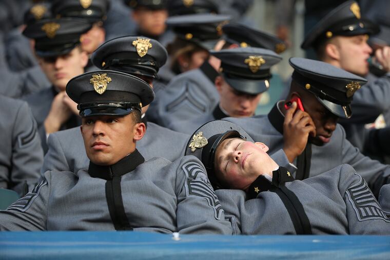 Army cadet Andrew Kane, right, sleeps as Donny Goff, left, looks on before the start of the annual Army Navy game at Lincoln Financial Field in Philadelphia, Pa. on December 12, 2015. ( DAVID MAIALETTI / Staff Photographer )