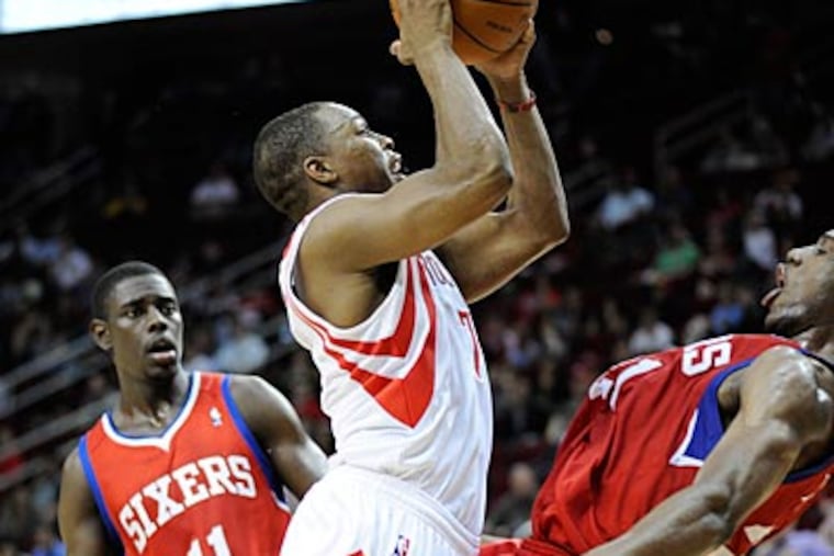 Rockets guard Kyle Lowrie gets fouled by Sixers forward Thad Young while driving the lane. (Pat Sullivan/AP)