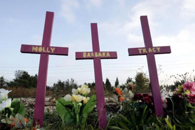 In this Wednesday, Nov. 14, 2007 photograph, three crosses stand, surrounded by flowers, in Egg Harbor Township, not far from the area where nearly a year ago, four Atlantic City-area prostitutes were found slain. (AP Photo/Mel Evans,file)