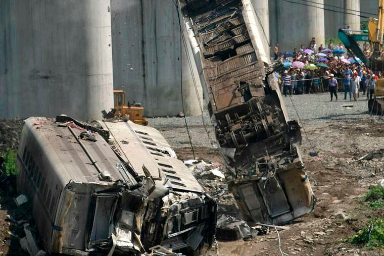 Workers remove a derailed train car from a bridge after the crash that killed 40 people in Wenzhou, China, in July.