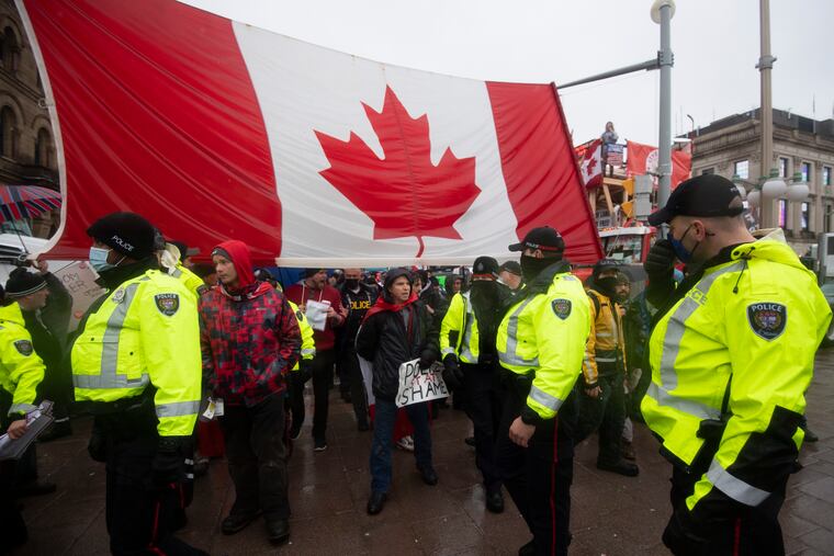 Police are followed by yelling protesters as they attempt to hand out a notices to protesters in Ottawa on Thursday.