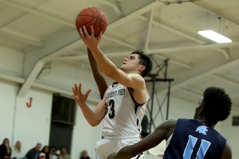 Chris Arizin of St. Joseph's Prep goes up for a shot against Mekhi Tribbett of Olney.