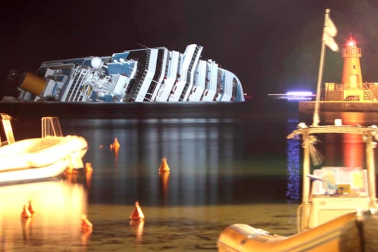 The cruise ship Costa Concordia lies on its side after running aground off the tiny Tuscan island of Giglio, Italy, on Jan. 18, 2012. The $450 million Costa Concordia cruise ship was carrying more than 4,200 passengers and crew when it slammed into a reef on Jan. 13, following an unauthorized maneuver by the captain. (AP File Photo/Gregorio Borgia)