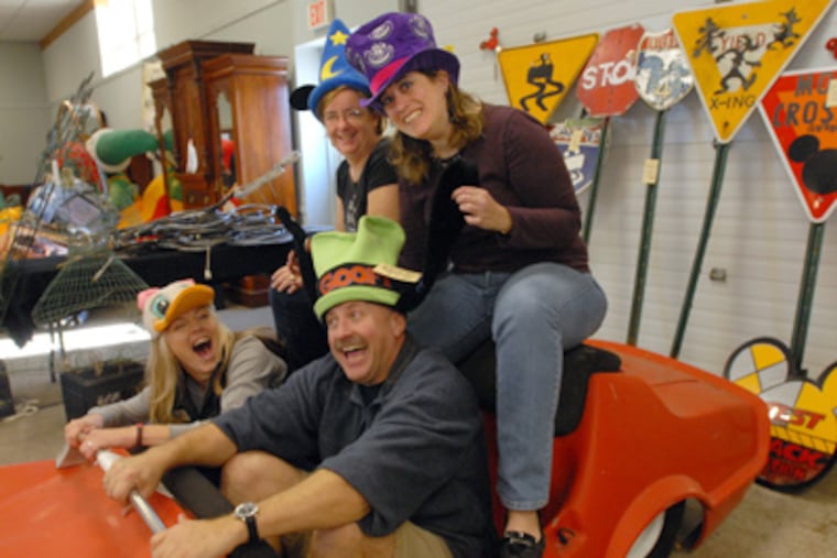 Auction staffers pose for a photo wearing Disney hats and sitting in a car. Front: Jessica Blevins and Frank Renner; back: Linda Gagliardi, left, and Alicia Barnett, right. (April Saul / Staff Photographer)