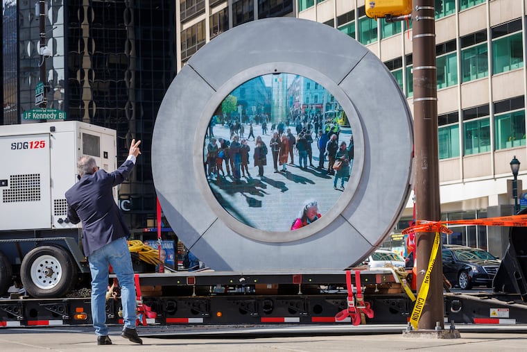 Joe Callahan, a director of the Portals project, flashes a peace sign to viewers of the Philadelphia Portal to the World. The Portal was moved from LOVE Park to the City Hall courtyar, Monday, April 14, 2025.