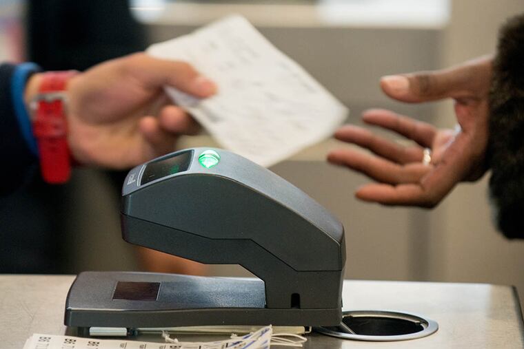 A JetBlue Airways Corp. employee scans a passenger's ticket to board a flight at John F. Kennedy International Airport (JFK) in New York, N.Y. on Jan. 28, 2014. ( Craig Warga / Bloomberg )